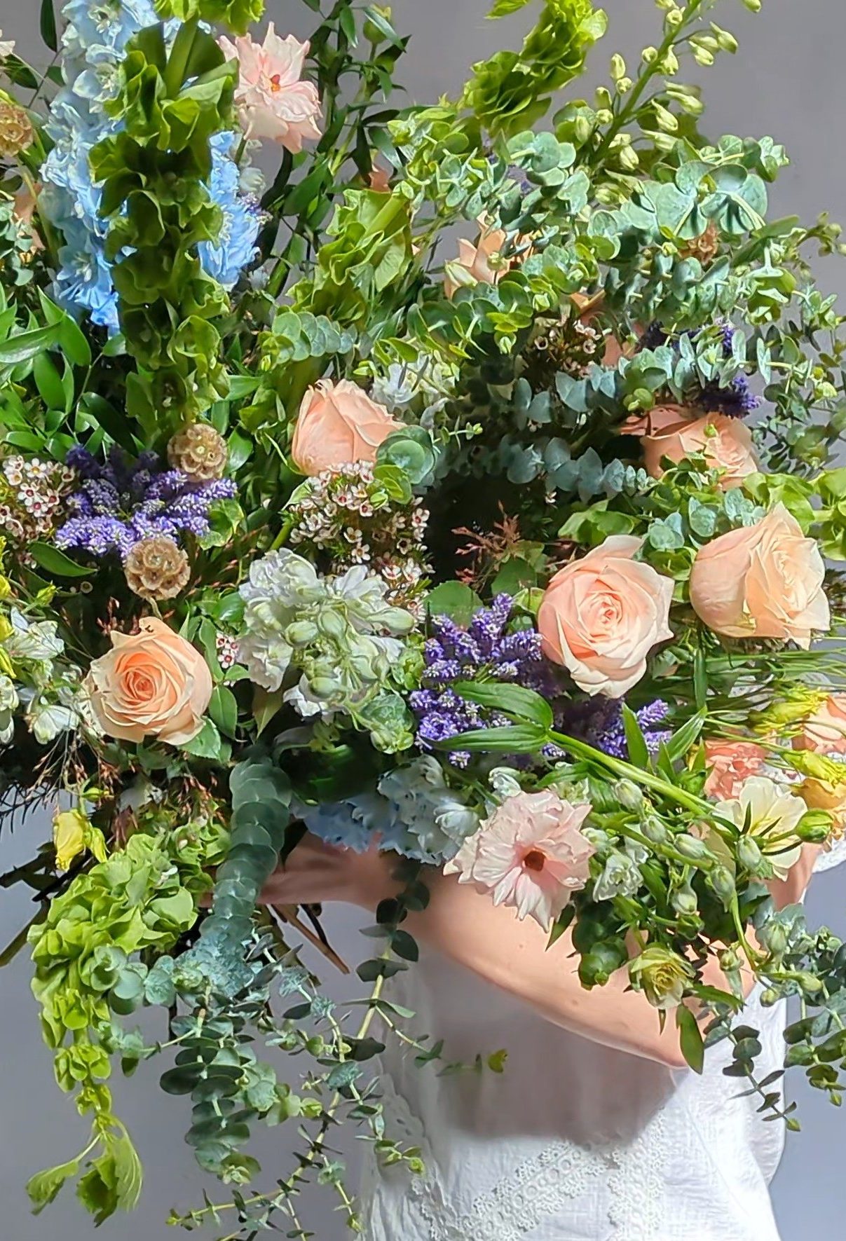 A lavish and wild combination of luxurious pastel flowers. Including soft peach roses, scented white stocks and frilly butterfly ranunculus, mixed with complimenting scented and textured pale coloured flowers, hand tied into an extraordinary abundant hand tied bouquet.  