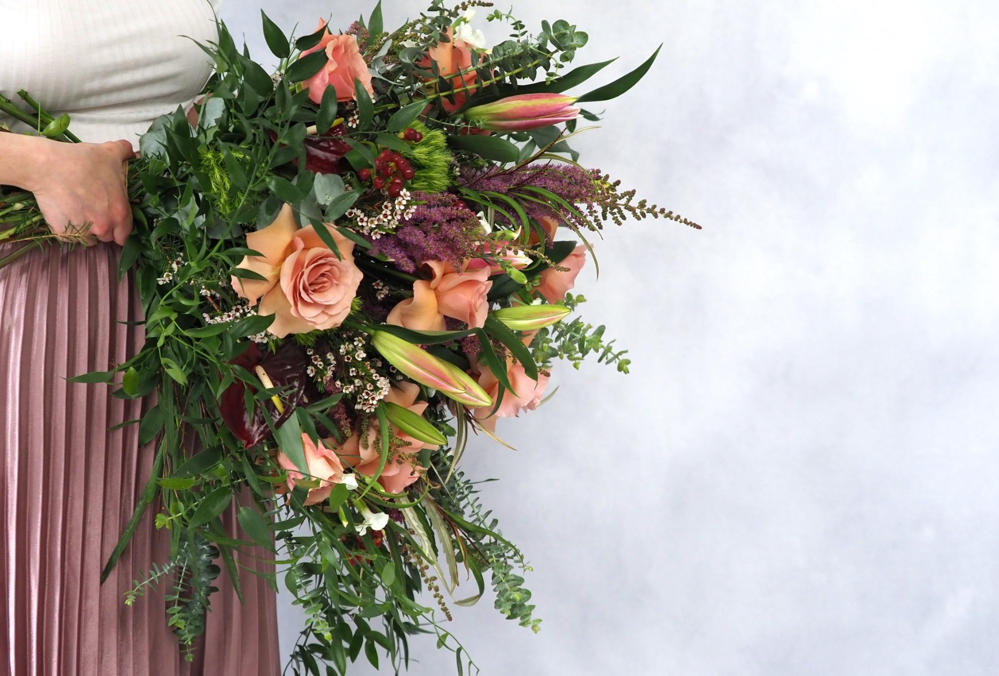 A rich and luxurious combination of peach, pink and purple flowers, hand tied into a large bouquet including scented lilies and textured greenery.  